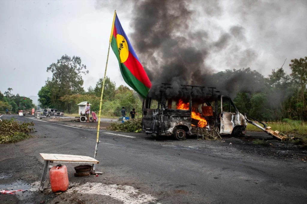 EuropaPress 5970852 19 may 2024 france paita kanak flag waves next to burning vehicle at an Moncloa