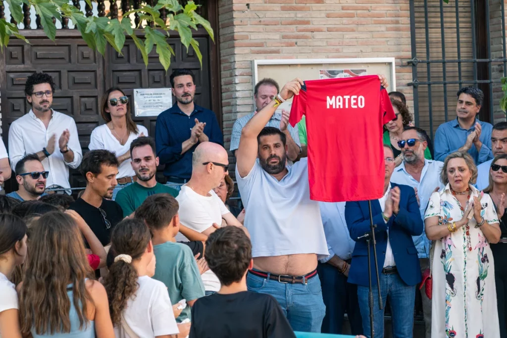 Varios familiares y amigos de Mateo, el niño asesinado, muestran una camiseta con su nombre, durante el minuto de silencio por el asesinato de un menor, en la puerta del Ayuntamiento de Mocejón