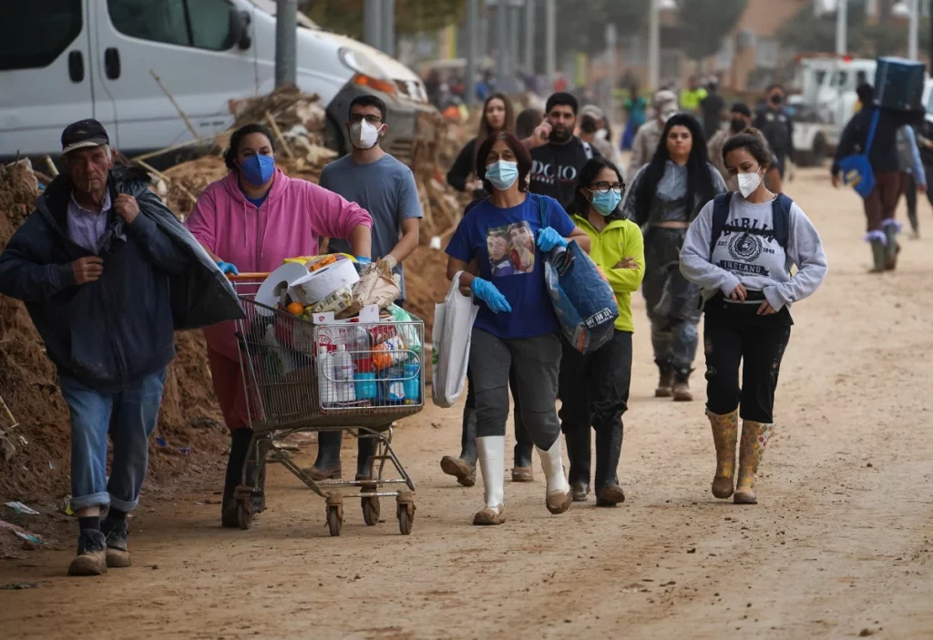 Riada de voluntarios ante un pasillo de escombros y sin recoger aún doce días después en Paiporta (Valencia)